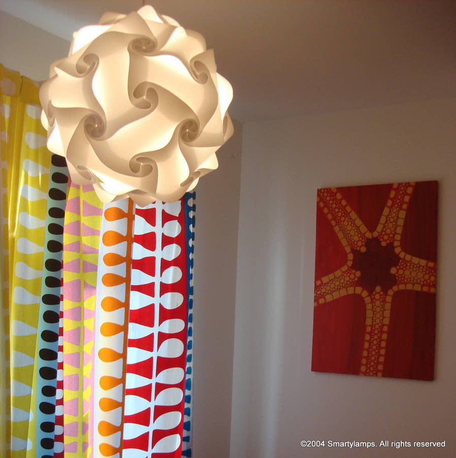 White swirling modern lamp shade in a colorful patterned room with abstract artwork on the wall