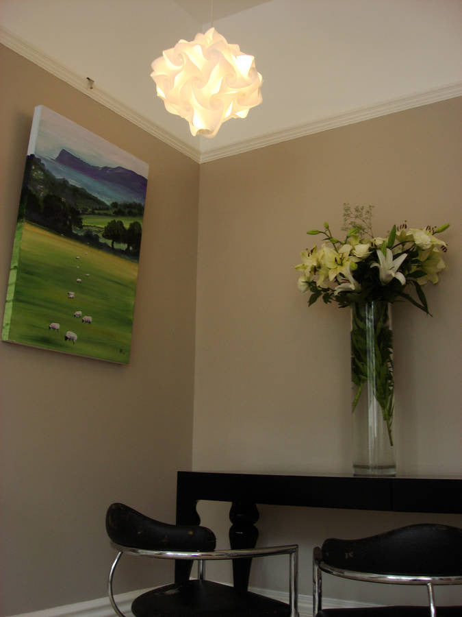 Elegant lighting fixture and floral decor in neutral-toned room