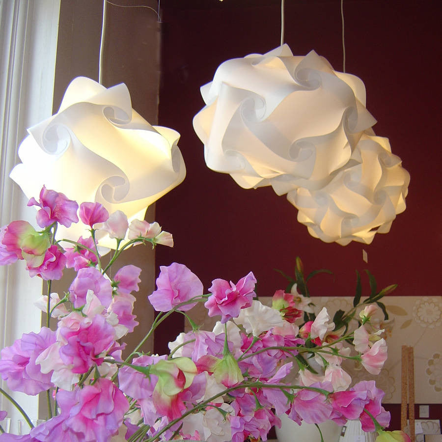 Stylish white lamps and vibrant pink flowers adorn the room