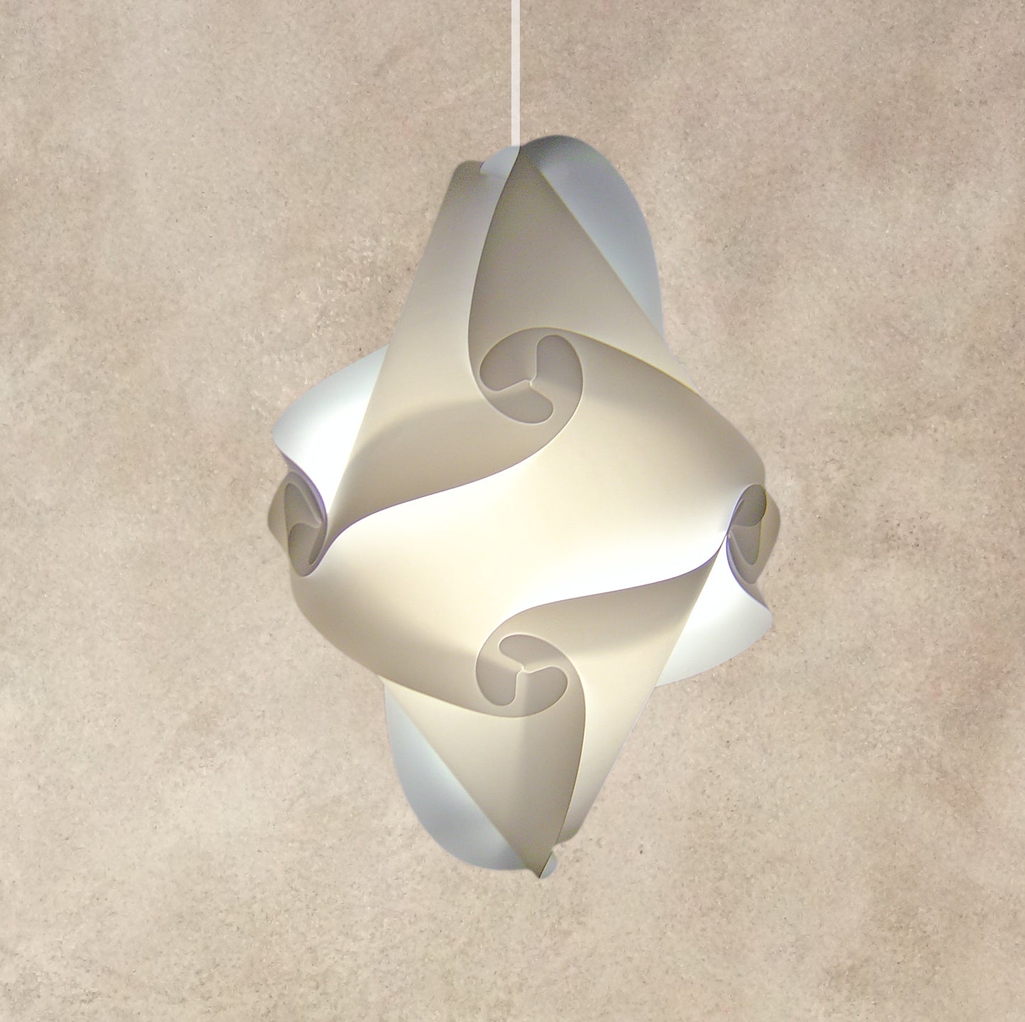 Modern white sculptural lampshade with swirling patterns hanging against a beige textured wall
