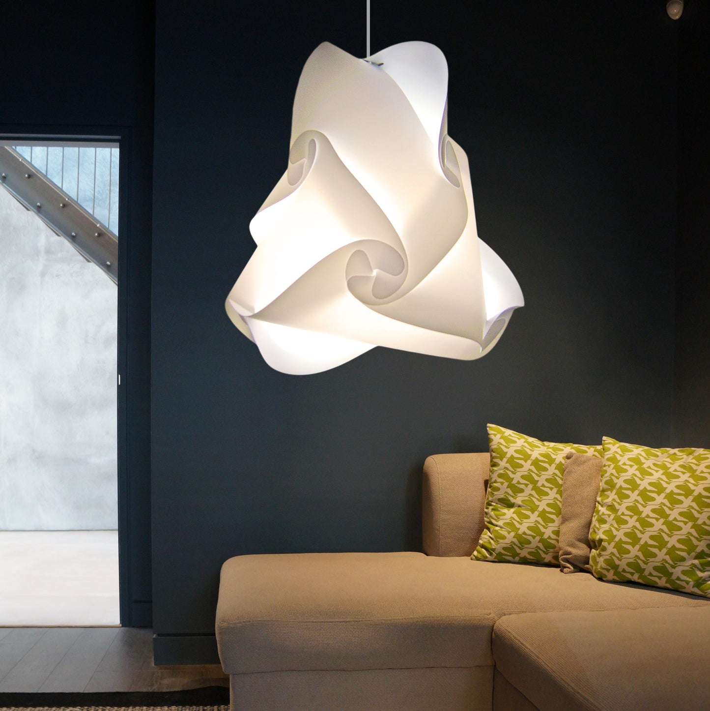 Elegant white pendant lamp, sculptural design, illuminating living room with cozy sofa and patterned cushions.