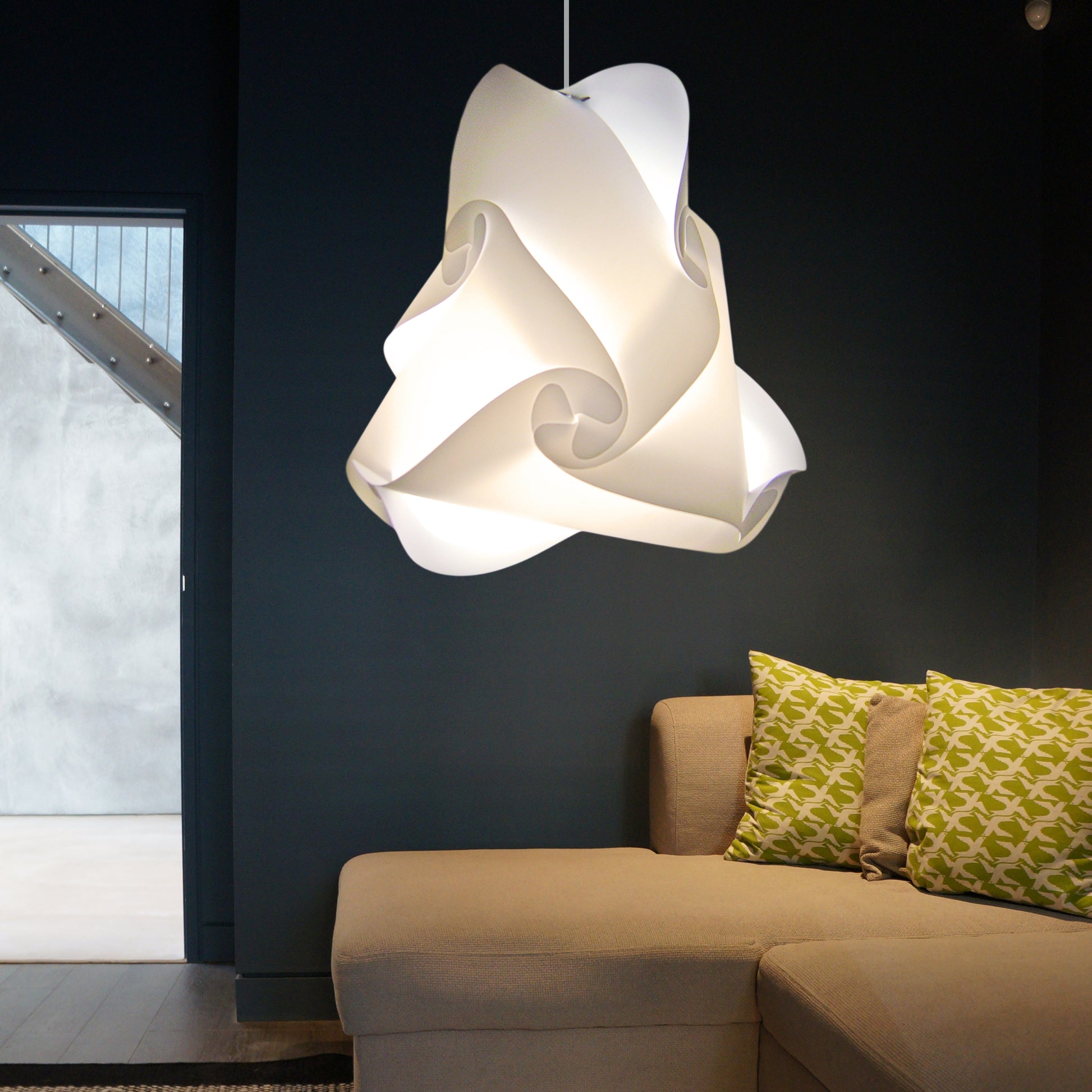 Elegant white pendant lamp, sculptural design, illuminating living room with cozy sofa and patterned cushions.