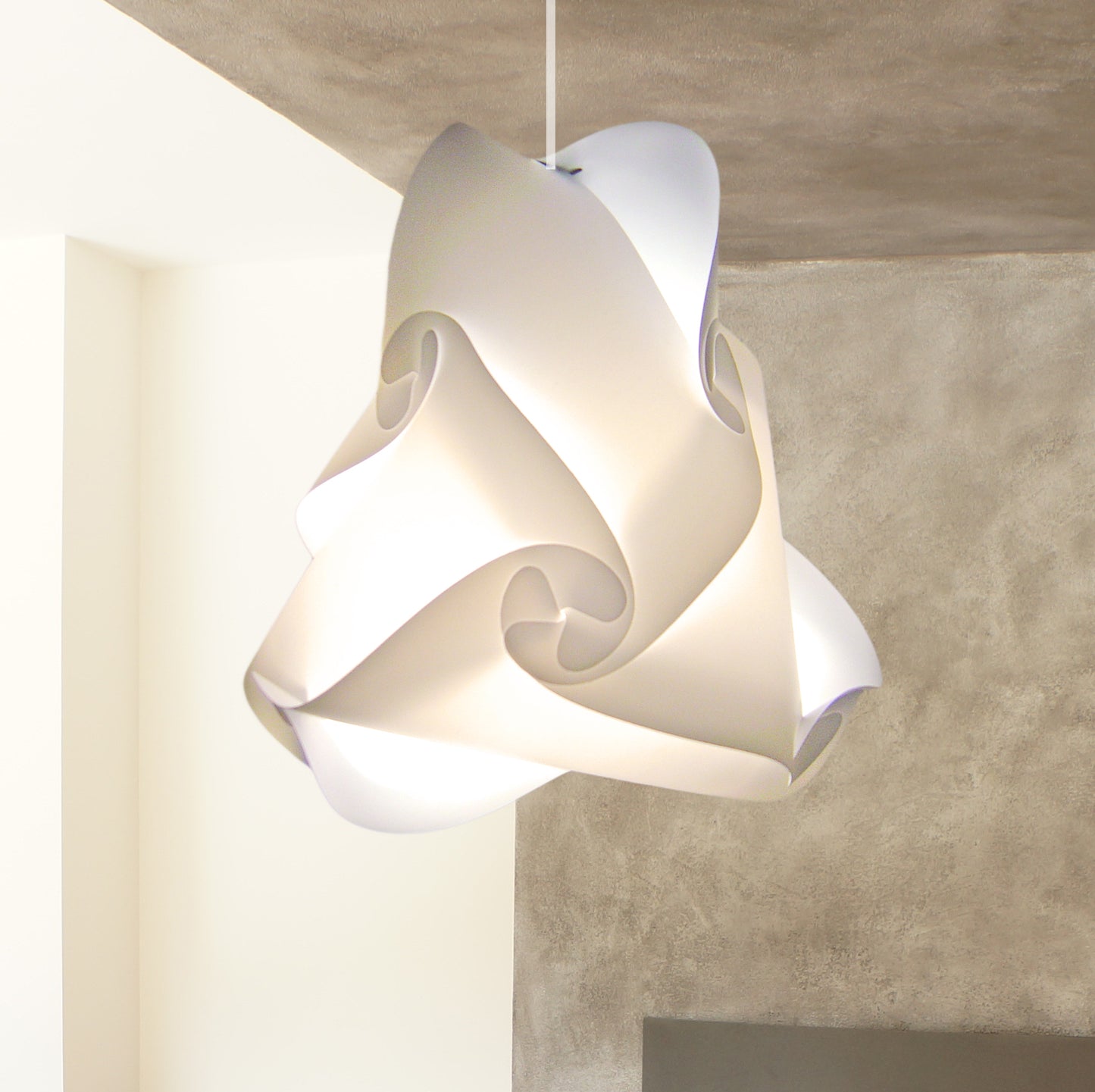Elegant white swirling lampshade suspended from the ceiling in a modern interior setting