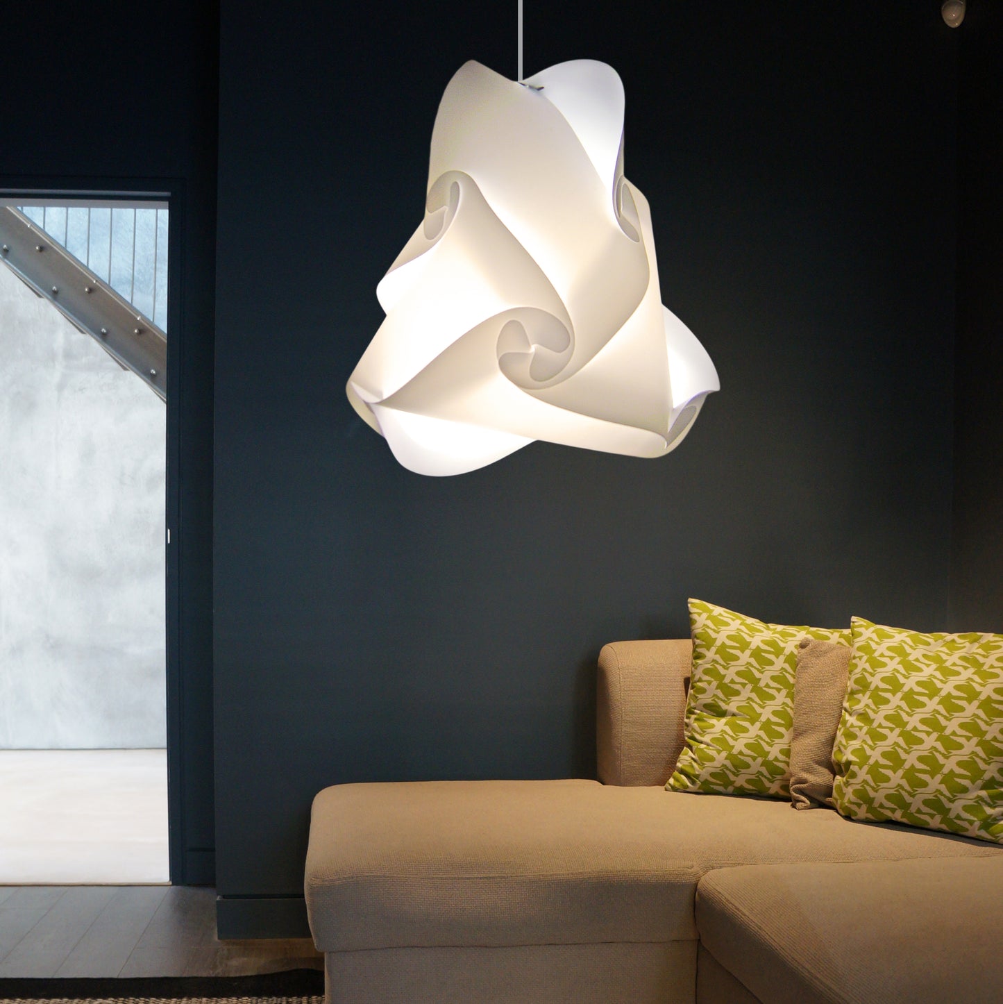 Elegant white lampshade pendant light in modern living room with beige sofa and patterned throw pillows.
