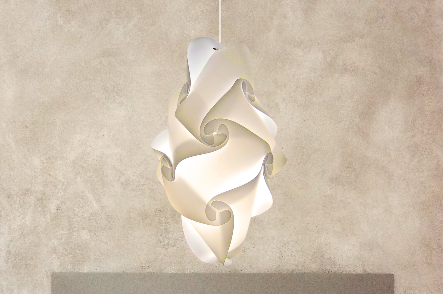 White sculptural pendant lampshade with intricate swirling design, creating a modern and elegant lighting fixture.
