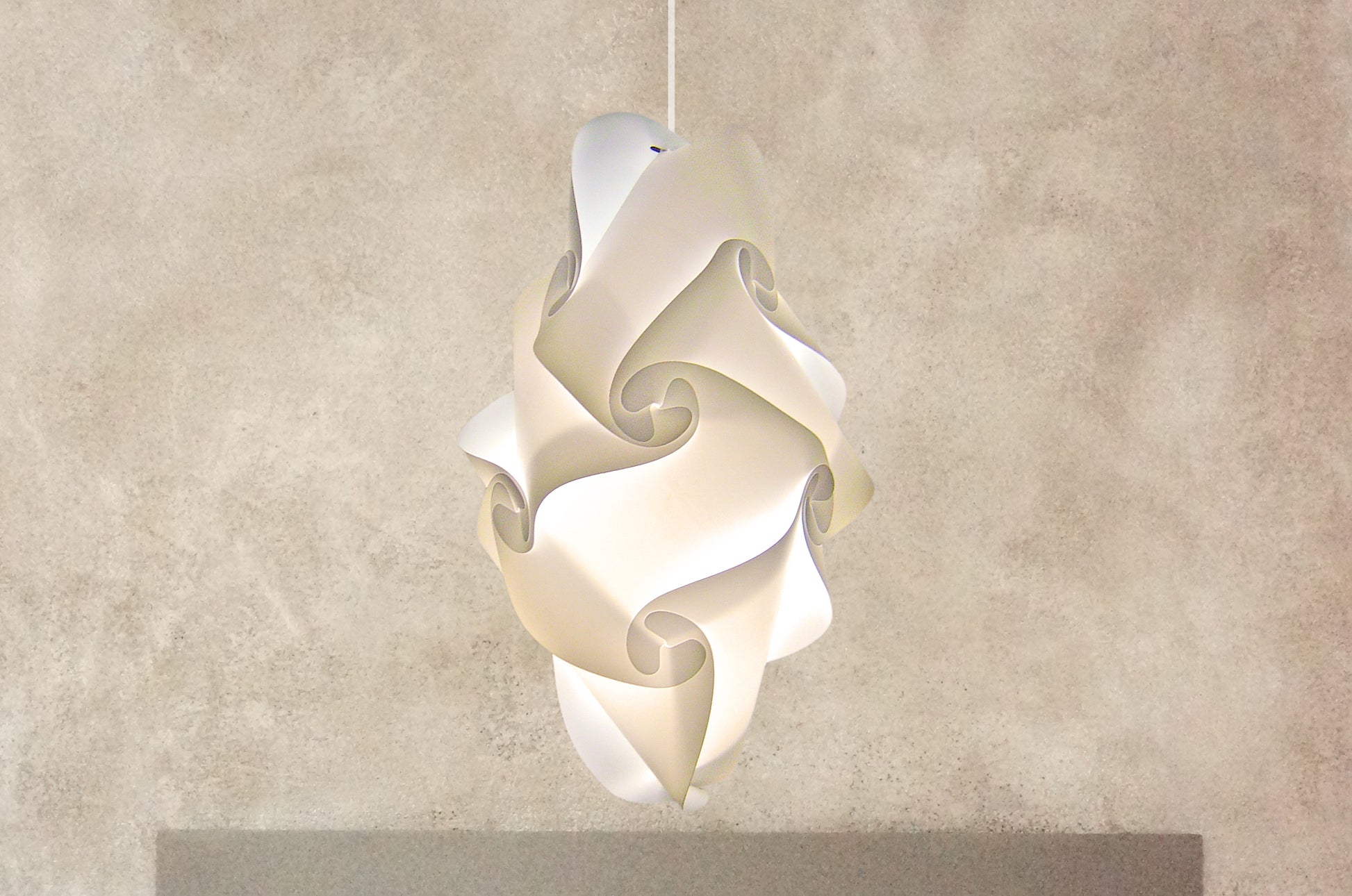 White sculptural pendant lampshade with intricate swirling design, creating a modern and elegant lighting fixture.