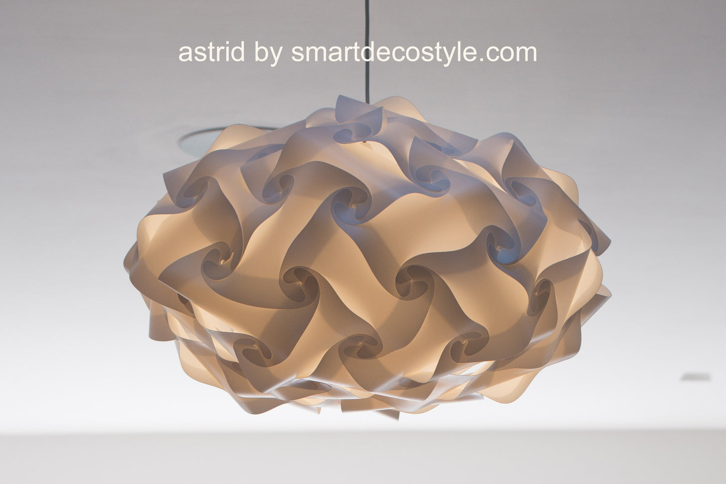 Elegant geometric light fixture: Intricately designed Smarty Lamps Astrid light shade, featuring overlapping spiral panels in neutral tones, providing warm ambient lighting.