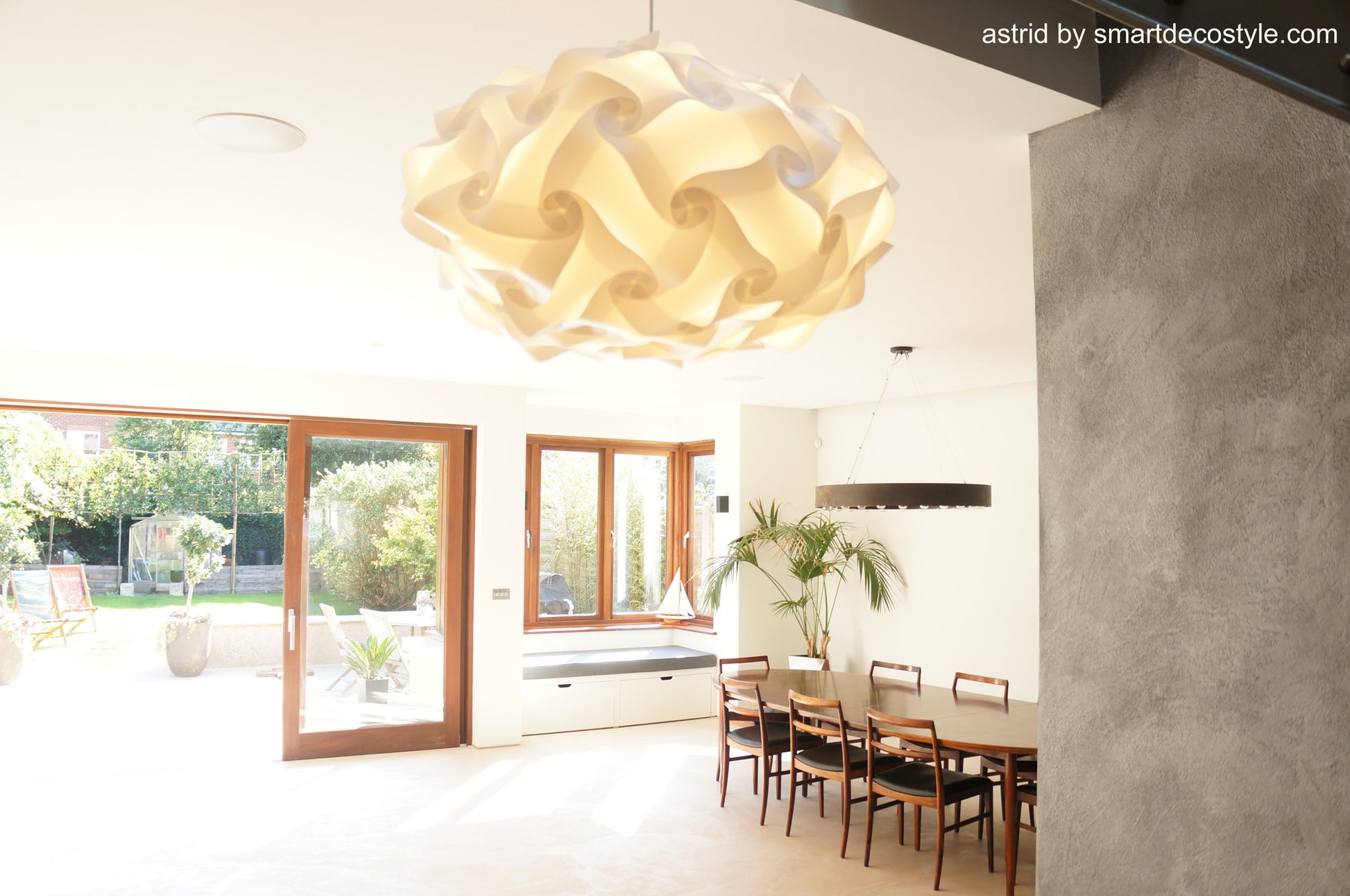 Elegant ivory paper lampshade, Smarty Lamps Astrid Light Shade, suspended from ceiling in modern, minimalist dining room with wood accents and patio view.
