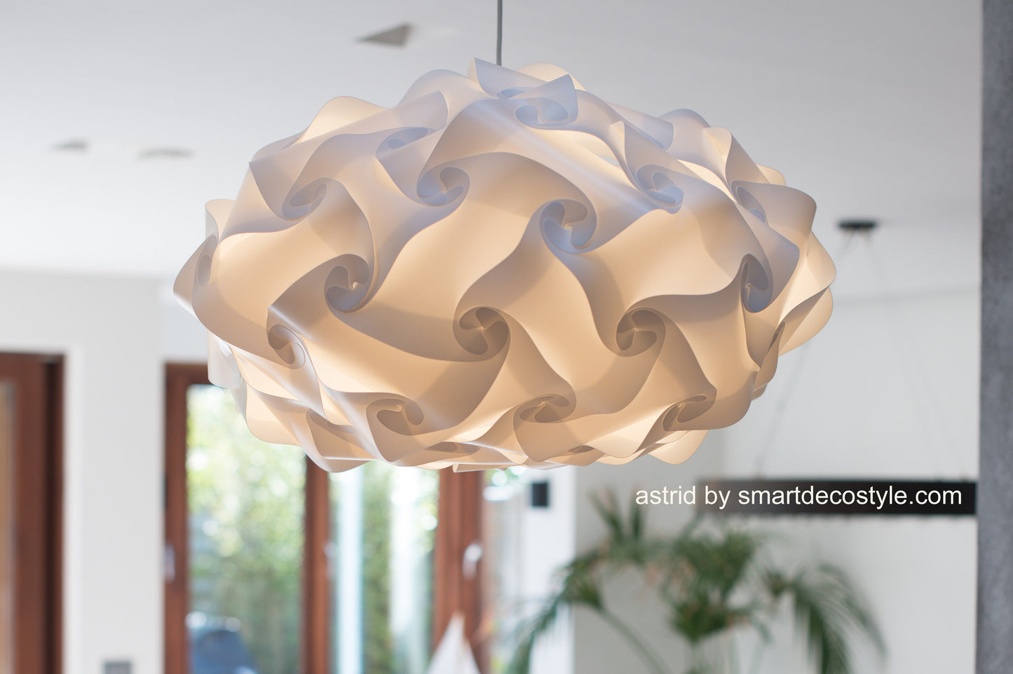 Modern white pendant lamp with intricate swirling design, illuminating a cozy interior space.