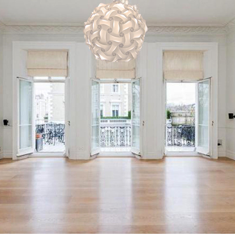 Modern white woven pendant lamp in elegant room with large windows overlooking city