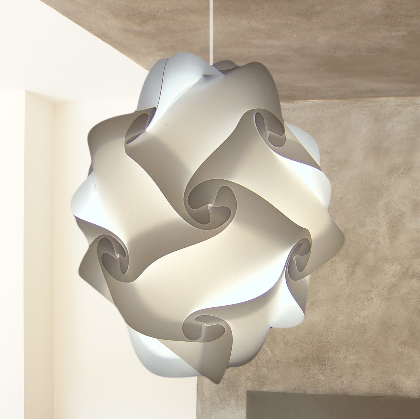 Sculptural white pendant lamp with swirling, abstract design in a modern interior