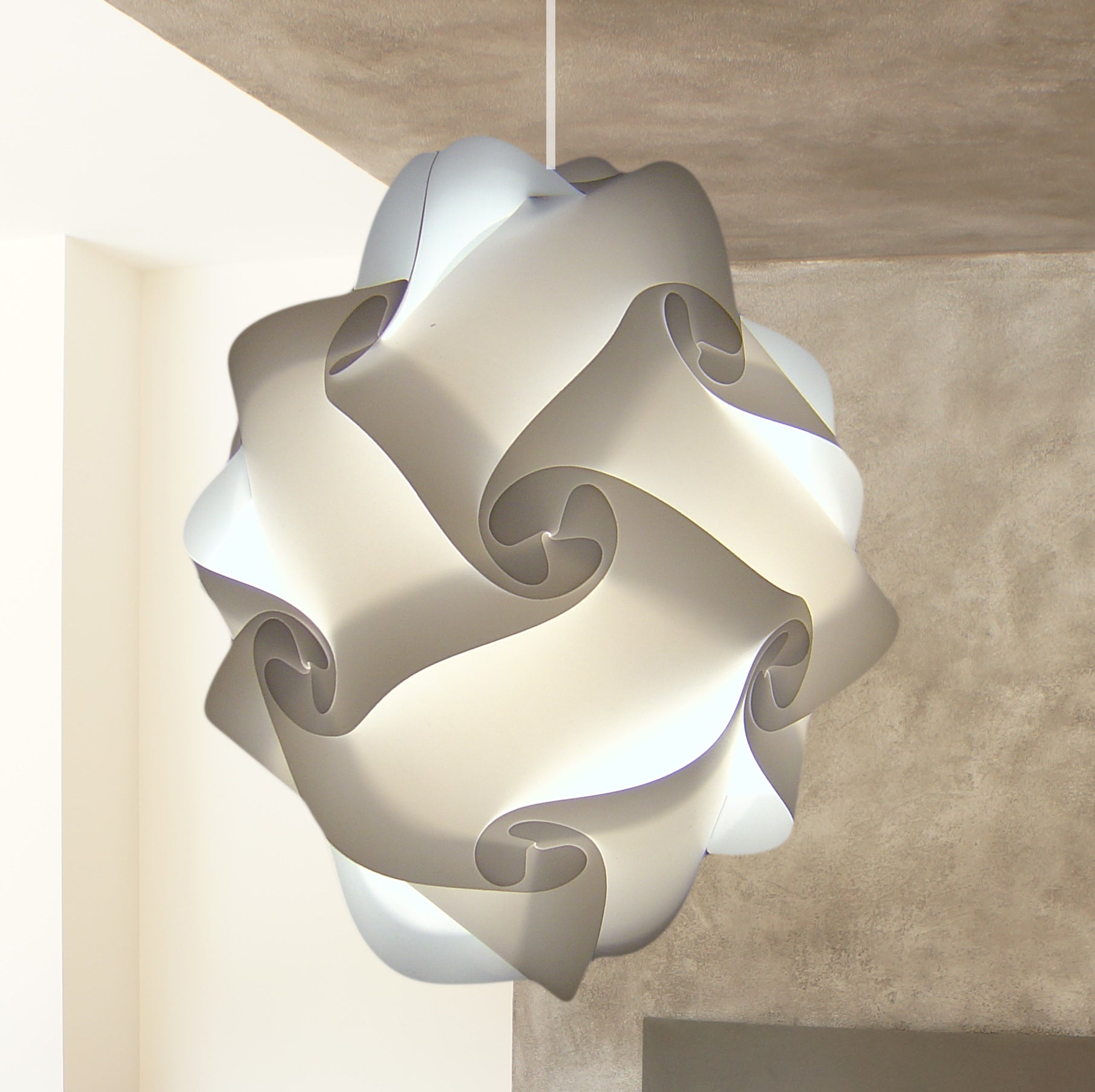Sculptural white pendant lamp with swirling, abstract design in a modern interior