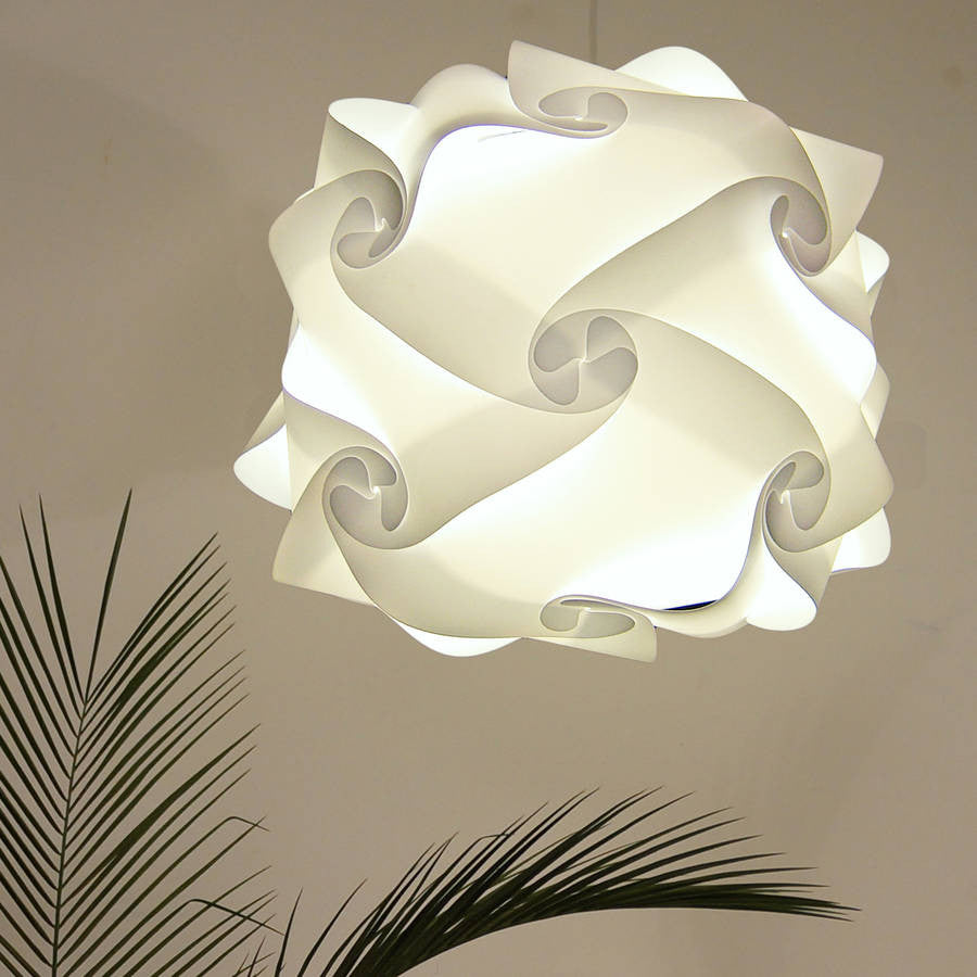 Elegant white swirling lampshade with palm leaves in foreground